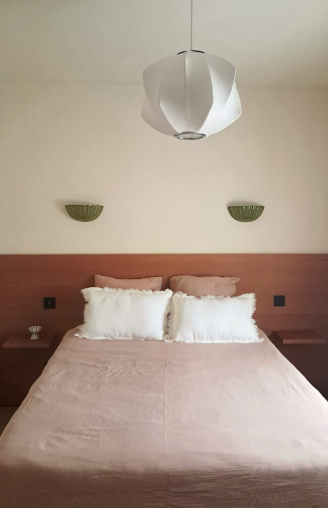 Image d'une chambre avec tête de lit sur-mesure et luminaires.